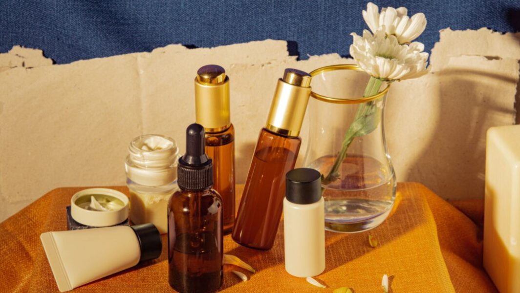 Des flacons cosmétiques devant un pot de fleurs // Source : Sandra Dans de capturenow