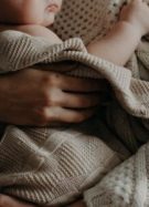 Un bébé dans les bras de son parent, Kristina Paukshtite de Pexels // Source : Kristina Paukshtite de Pexels